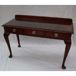 A 19th century mahogany side table with a raised back above a rectangular top and three drawers on