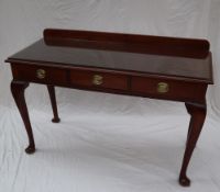 A 19th century mahogany side table with a raised back above a rectangular top and three drawers on