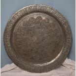 A Persian white metal table top / charger decorated with scrolls and leaves,