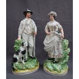 A pair of Staffordshire figures depicting a huntsman holding a gun with a dog at his feet on an