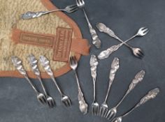 A set of twelve Tiffany silver cocktail forks with cherry terminals in their original cloth bag