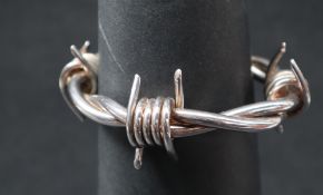 A white metal barbed wire bangle,