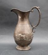 An Indian white metal jug, of baluster form with a C scrolling handle on a spreading foot,