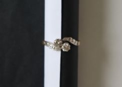 A two stone diamond ring, set with round old cut diamonds each approximately 0.