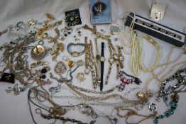 Assorted costume jewellery including faux pearls, brooches, wristwatches,