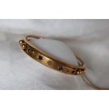 A 9ct gold sapphire and diamond hinged bangle, set with four sapphires and three diamonds,