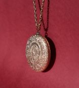 A yellow metal locket of oval form on a 9ct gold chain,