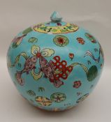 A Chinese porcelain vase and cover of squat form decorated with fish and swags to a turquoise