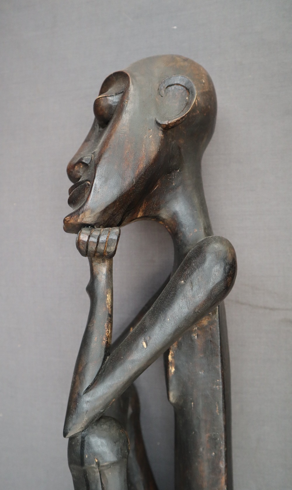 An African carving of a seated figure with his head resting on his right hand on a square plinth, - Image 6 of 8