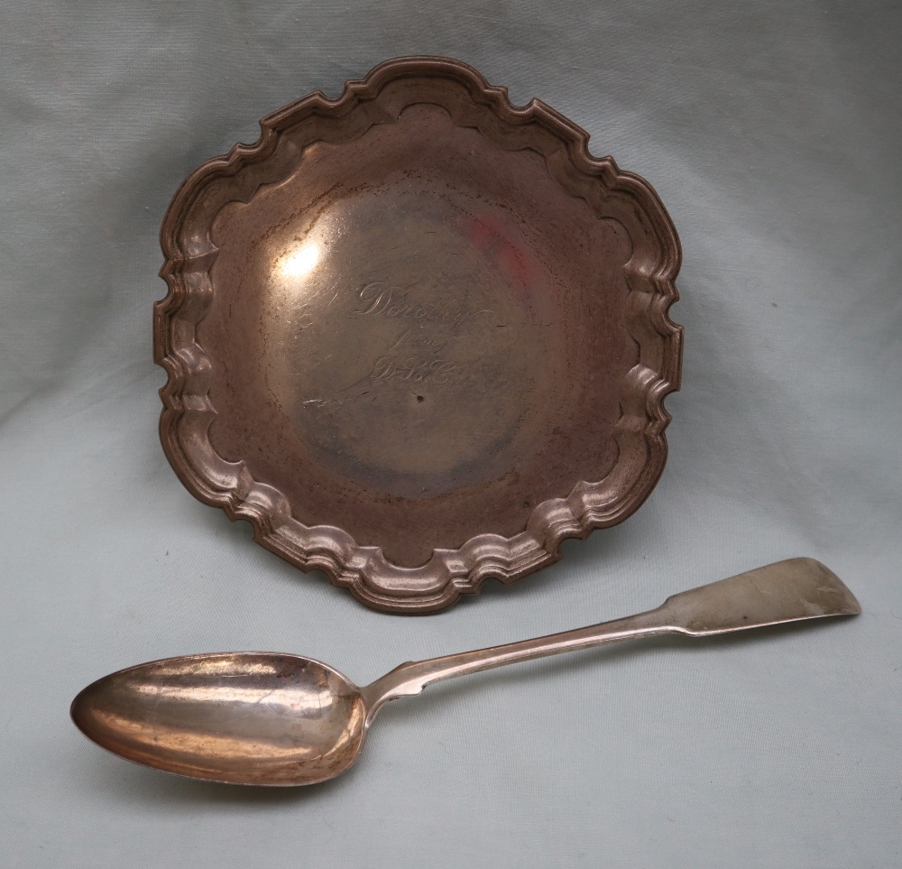A George V silver waiter of shaped circular form, engraved to the centre on three scrolling feet,