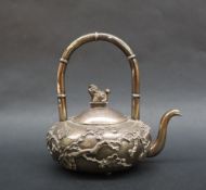 A Chinese white metal kettle, with a hooped bamboo hands, the domed cover with dog of foo finial,