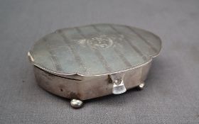 A George V silver jewellery box of pointed oval form, with line decoration, on four ball feet,