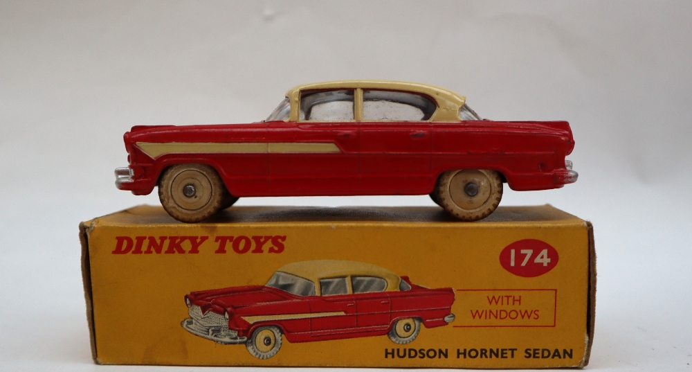 A Dinky Toys 174 Hudson Hornet Sedan with red lower body, cream roof, flash and hubs,