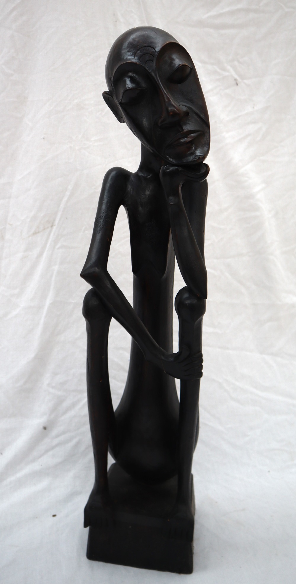 An African carving of a seated figure with his head resting on his right hand on a square plinth, - Image 2 of 8