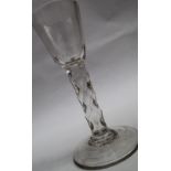 A 19th century wine glass with a tapering bowl and a diamond faceted stem on a spreading foot,