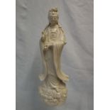 A Chinese Blanc de chine of a female dignitary with right hand raised and a vase in her left hand