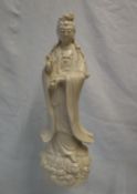 A Chinese Blanc de chine of a female dignitary with right hand raised and a vase in her left hand