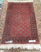 A small red ground Turkoman rug, with multiple guls and crosses to multiple guard stripes,