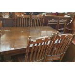 A 20th century oak extending refectory table with cup and cover legs and four oak dining chairs