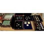 A wooden display case of uncirculated American quarters and six display boxes of coins