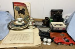 A collection of Rayban prescription glasses together with binoculars, model cars, pottery plates,