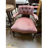 An Edwardian upholstered horseshoe shaped chair with button back upholstery,