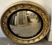 A gilt framed convex wall mirror with ball mounts