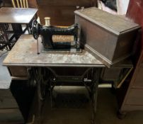 A Singer sewing machine inset into an oak table with treadle base