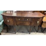 A Regency mahogany sideboard with a shaped top above two central drawers,