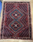 A red ground rug with geometric central panels and botehs,