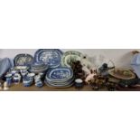 A collection of blue and white willow pattern meat plates together with other blue and white plates,