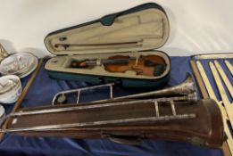 A Hawkes electroplated trombone within a leather case together with a child's violin,