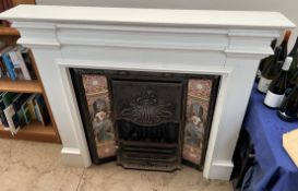 An Art Nouveau inspired fire place with tiles and a white painted fire surround