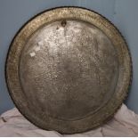 A Persian white metal table top / charger decorated with scrolls and leaves,