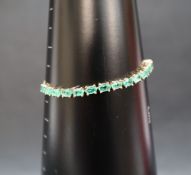 Gemporia - A 9ct gold Tomas Rae emerald slider bracelet, set with oval emeralds totalling 3.