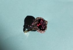 Gemporia - A 9ct gold garnet and white zircon ring, set with oval garnets and round white zircons,