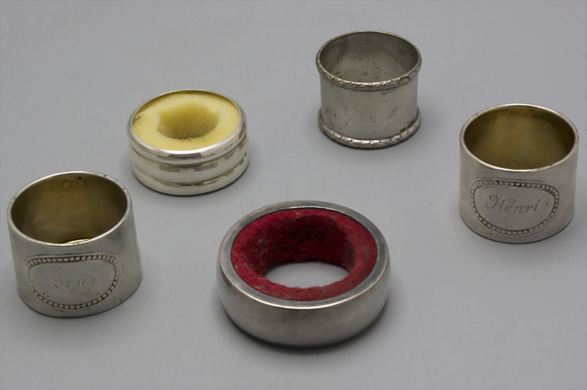 Konvolut aus 5 Silber Serviettenringen und Tropfenfängern / A set of 5 silver napkin rings and ...