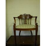 A Victorian elbow chair the curved back with classical inlaid motifs above turned columns and