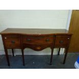 An early 20th century reproduction mahogany sideboard of serpentine form the frieze drawer above a