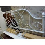 A charming metal bedframe of curly design in white comprising two ends, two side struts and wooden