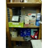 Two shelves of mainly boxed mixed items including a hand operated paper shedder, a pasta machine, an