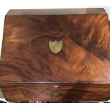 An early 19th century sloped mahogany box, probably originally a desk, with brass shield