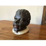 A 19th century painted terracotta head of a young black man 12 x 13 x 17 cm [This lot is viewed at