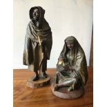 A pair of Italian 19th century papier maché figures of Arabs: a seated woman and a standing man, man