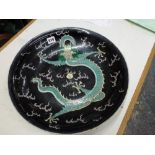 A large Chinese porcelain famille noire dish, early 20th century, enamelled with a dragon and