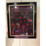 A collection of embroidered badges in red on black presented in two frames, 46 x 56 cm [This lot