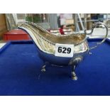 A good George III Irish silver sauceboat with punched rim, on three hoof feet, 17 cm long, maker's