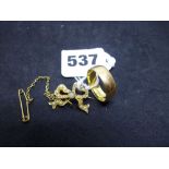 A 22 ct gold wedding band, 5.2 gm; and a small bow brooch, tests as 15 ct, set with split pearls,