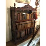 A French provincial style walnut etagere of three shelves, the frieze and apron carved with