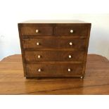 An early 19th century mahogany miniature chest of two short over three long drawers, with turned